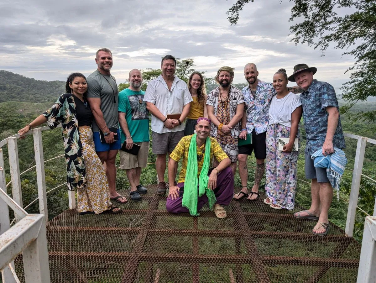 Guests holding journals on a lookout above the forest